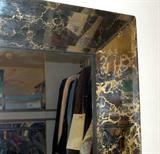 Large glass framed mirror with black and gilt accents.