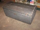 Primitive roundtop trunk with hand wrought handles news papers lining the top of trunk inside are dated 1841.