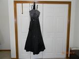 Up for auction is a beautiful "Mori Lee" evening gown. This unique black gown has square and round sequins. This size 14, sleeveless gown has a lace-up back, and the coordinating scarf is included. No obvious flaws.The original price tag is attached. It was priced at $199.