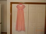 “Emma Domb California” Long pale pink lined gown with long ruffle around neck.
Size 5. Satin sash comes to bow.