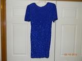 “Laurence Kazar New York Dress”. Sapphire blue, 100% silk dress with
sequins and bead trim around hem, neckline & sleeves. Shoulder pads.
Light weight for this type of dress. Size large.