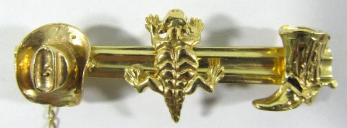 Lot#:	70
Description:	Jewelry 14kt Yellow Gold Western Tie Clip
Fabulous 14kt yellow gold tie clip with Western style designs. Featuring applied cowboy hat, horny toad, and cowboy boot figural accents. Includes safety chain which attaches to shirt button. Measures: 2.5" wide, total weight: 8.4 dwt. 