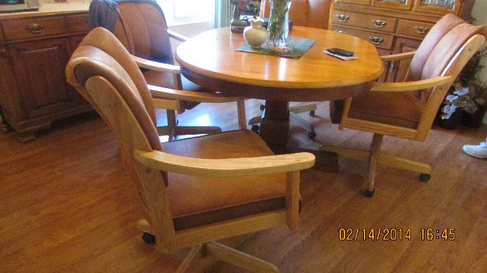 Large center base dining table four caster chairs
