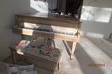 Wurlitzer baby grand piano with antiqued finish, needlepoint seat cover