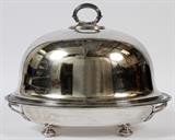 Lot#2087, ELKINGTON SHEFFIELD PLATE HOT WATER PLATTER AND DOME 13" L 15"Elkington & Co footed platter with hot water base. Platter has impressed Elkington trademarks including crown, as well as being raised on four round feet and having carrying handles . Engraved crest of eagle on edge. Base is hollow for insertion of hot water with screw cap. Dome cover has impressed Elkington trademark and has an engraved crest of a horse-like figure with an arrow. E & Co.