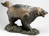 Lot#2135, PETER ROMANO BRONZE WOLVERINE SCULPTURE, 2006, 20" X 39", "THEY CALL ME SIR"Peter Romano (American 20th C.).  Having a "Rivers Edge" foundry mark.  This  bronze is cast in one piece. having a gold to dark brown patina.  Numbered edition 27/250.  On a green marble base.