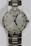 Lot#1041, GENEVE 18KT WHITE GOLD LADY'S WRISTWATCH, L 7"Swiss movement, with a diamond dial. Having channel set diamonds surrounding the face, measuring approximately 60 grams in total weight.