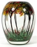 Lot#1113, HEILMAN & ROESSLER, STUDIO GLASS PAPERWEIGHT VASE, 1983, H 6 1/4", 'AUTUMN'Chris Heilman and Joyce Roessler, studio glass paperweight vase entitled "Autumn", #5. Transparent glass, internally decorated with autumn landscape. Signed and dated at underside; measuring H. 6 1/4" x 4 1/2".