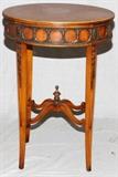 Lot#256, JOHN WIDDICOMB CO., SHERATON STYLE SIDE TABLE, H 28" W 20"Oval form top, with one drawer at the frieze. Raised on straight, tapered legs, having a shaped joined lower stretcher with an acorn finial. The table features applied brass mounts along the frieze and legs, decorated in circle wreath and floral motif. Early 20th Century. Measures H. 28" x 20" x 17". John Widdicomb Co. label at interior of drawer.
