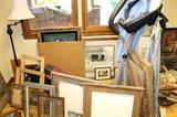 Artwork, frames, and elliptical machine. The two big pictures under the window have been pulled by the family. 
