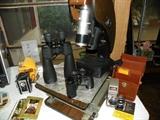Several old cameras and high power binoculars.