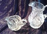 C5   American Brilliant Period Cut Crystal Pitcher 7 1/2” tall and 5 ½” at the base beautiful Buss Cuts and Diamond cut details, Crystal Creamer, 5” in Diameter and 3”tall, etched Flowers along with Diamond and Star burst detailing (Excellent Condition)