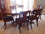 Antique dining table with leaf and surface pad and six chairs with forest-green velvet seats