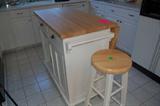 Moveable kitchen island with butcher block top.
