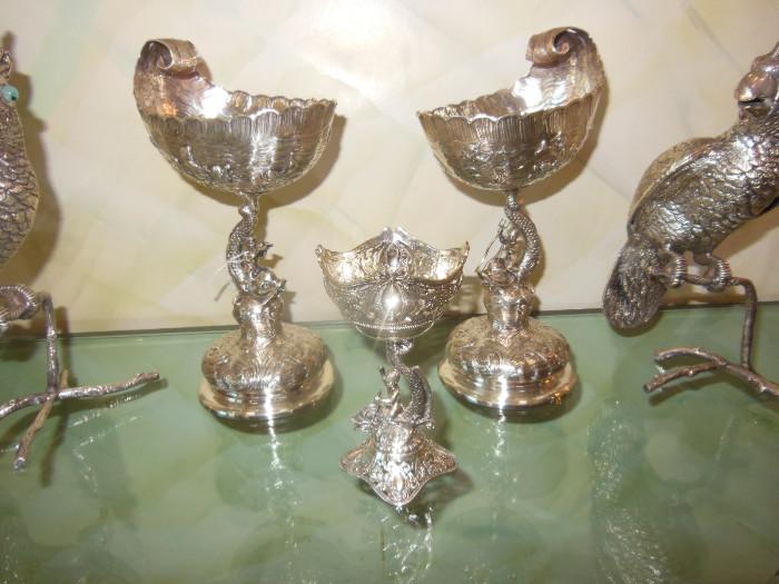 A Spectacular pair of Continental Silver Shell-form Compotes with Dolphin & Cherub Pedestals, along with an Extremely Fine 19th. C. Sterling Silver Footed Dolphin Compote, and a pair of Silverplate Cockatoos on Limbs.