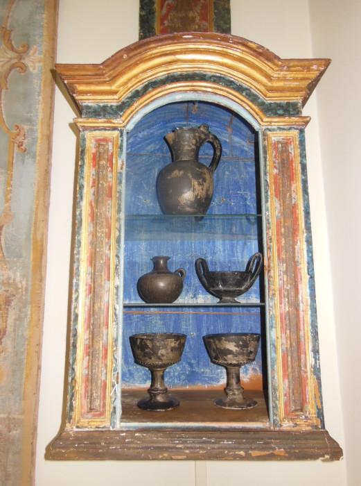 One of a pair of 18th. C. Italian Painted Cabinets (door above) with a collection of Etruscan Boeotian 4th. C. BC Black Pottery