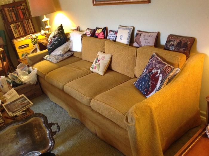 one of 2 long modern sofas, needlepoint pillows