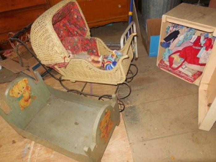 The wicker doll carriage has an American Character baby doll inside.  The 1930's wood doll bed has blue paint, the other bed is cast iron headboard and foot.  The wardrobe is full of doll clothes.  The wardrobe is painted pine.  