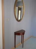 Cherrywood demilune console table                          Gilt framed oval mirror
