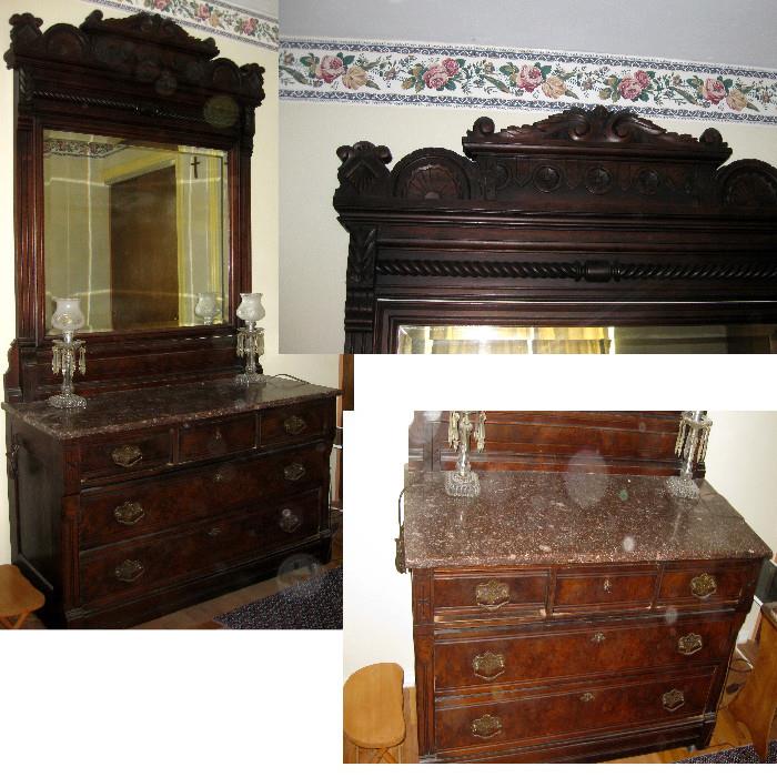 Large dresser with marble top and ornate header.