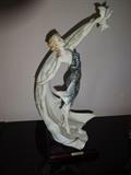 A porcelain cast by Giuseppe Armani depicting a woman and a bird. Hand painted and dated to 1992, it is 5.25" square at the base and stands 15" high.