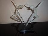 A glass sculpture of dancers, one is in clear glass, the other in frosted glass. It stands 9" high by 9" long by 4" wide