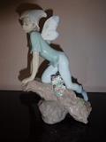 This depiction of a fairy on a rock is hand painted porcelain by Lladro and entitled "Priviledge." It stands 9" high by 6" long by 3.5" wide.