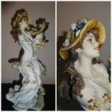 A piece by Giuseppe Armani entitled "Lucia" in which a woman holding her dog is depicted in hand painted porcelain. It stands 12" high by 5" wide by 5" long and is circa 1994.