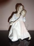 A depiction of a Mother and Child in nightgowns, this Lladro piece is hand painted porcelain. It stands 8" high by 6" wide by 6" long.