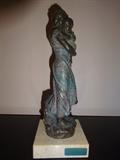 A piece in solid brass with a marble bass. The depiction is of a mother holding a child and is by J.M. Belsa. It stands 12" high by 4" square.