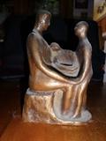 A Brown mother and child piece by Harry Moore. It depicts three abstract figures and stands 6" by 4".