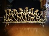 A brass Menorah depicting various people holding up the candle sconces. It is 9" long by 4" high.
