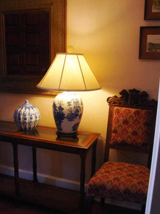 Another of the dining chairs is shown with one of a pair of Blue Willow lamps and a Thai gourd shaped jar. Console table matches end tables and coffee tables.