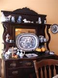 A mix of new and older Blue Willow and other patterns. Shabby chic dark stained oak sideboard with all beading and applied trims intact. No breaks in the curved supports.
