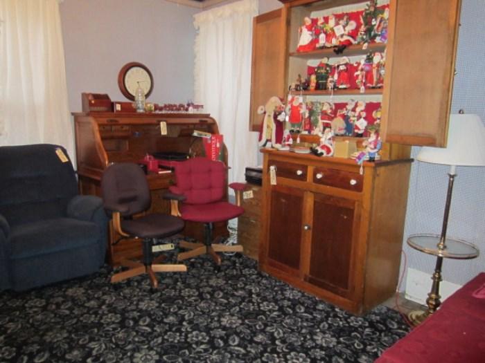 Winning bidders roll top desk, great primitive cabinet loaded with Christmas figurines.  Nice large area rug.