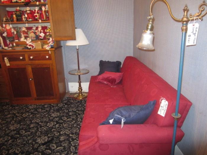 Red upholstered couch.  Floor lamps.