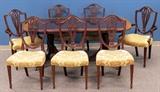 Lot#2119, BAKER MAHOGANY DINING SET, 9 PCS/Includes one inlaid mahogany dining table, raised on casters, measuring H. 30" x 95" x 46"; together with 6 side chairs, and 2 open armchairs, all having shield backs, and urn form center back splats, with upholstered seats in pale yellow, measuring H. 39 1/2". Property from the Estate of Elmore Leonard, Bloomfield Hills, MI.