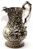 Lot#1004, GALE & WILLIS COIN SILVER WATER PITCHER, C. 1860, H 11 1/2", RETAILED BY TIFFANY & CO.Baluster-form with repousse floral and scroll pattern overall, stamped "1920, Tiffany & Co., G & W, 4" at the underside (see additional photo).  Weighs approximately 34.4 troy oz.