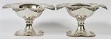Lot#1007, REDLICH & CO. STERLING COMPOTES, EARLY 20TH C., PAIR, H 5", DIA 9 1/2"Each sterling silver compote has a scalloped rim with floral and bowknot motifs, engraved script "McM" monogram at the well, raised on a conforming pedestal base; stamped with logo for Redlich & Co., number 1062, "Sterling", and retailed by Galt and Bro.  Totaling approximately 33.5 troy oz.