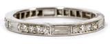 Lot#1400, PLATINUM & DIAMOND ETERNITY BAND.Platinum setting with six baguette cut diamonds alternating with six groups of three enhancement diamonds.  Weighs approximately 3 grams in total.