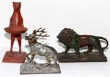 Lot#1618, DECORATIVE METAL ACCENTS, THREE, H 6 1/2"-10 1/2"Including a cat figure holding a shell, and a stag; together with a ceramic walking lion.