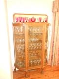 Oak China cupboard with mirror on top, cranberry glass, full of crystal