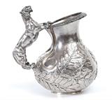 Lot 1001:  FIGURAL TIGER HANDLE STERLING SILVER PITCHER: Unmarked, appears to us to be the work of a Hanau region silversmith, possibly B. Neresheimer & Sons. Figural handle in the form of a standing tiger. Repousse leaf and berry motif on sides, embossed patterned rim. Monogram ''M. B.'' and scratch numbers 4217 8848 8122 on base, scratched tested as sterling silver. 10 1/4'' h. x 9 3/4'' x 6 3/4''. Approx. 61.5 troy oz.
CONDITION: Ding to one side, interior scratches.