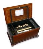 Lot 1011:  LARGE SWISS INLAID CYLINDER MUSIC BOX WITH BELLS: Mahogany case, hinged lid with marquetry inlay musical instruments and floral motif in central medallion, string inlay on top and sides, bracket feet. Unmarked movement attributed to Nicole Freres with single comb, 6 bells, 12 song cylinder. Currently plays nicely, 14 1/4'' h. x 27'' x 15 1/2''. Est. $2000/3000**
CONDITION: Rubs to case, currently playing however not guaranteed to continue.