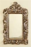 Lot 1100: LARGE ANTIQUE CARVED ITALIAN MIRROR: Deeply carved and open work frame with a Rococo foliate motif, silver gilt, beveled glass mirror. 54'' h. x 35'' x 4 1/2''.
CONDITION: Spotting and streaks to mirror, restoration to frame. 