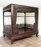 Lot 1061:  PROFUSLEY CARVED CHINESE WEDDING BED: Front panels with figures, mythical creatures, processions and foliate motifs. Reticulated side and back top and bottom panels, base with carved dragon in clouds motifs. All on 4 paw feet, overall 81 1/2'' h. x 85'' x 62''. Est. $4000/6000**
CONDITION: Wear consistent with age and use. Shippers note: breaks down into panels, base and top.
