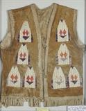 Lot 1201: SIOUX QUILL WORK HIDE VEST: Circa 1890-1910, deer hide vest with polychrome porcupine quill work in geometric patterns on both front and back with fringed lower trim. Tradition holds this vest was once in the Heard Collection in Arizona, and may have been used in Wild West shows, unfortunately no paperwork to substantiate. Vest is currently framed in a double panel carved frame, overall measures 34 1/4'' x 28 1/4'' x 1 3/4''. Est. $3000/5000**
CONDITION: Some fading to quill. 