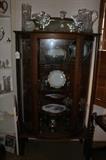 Wonderful antique curved glasss display cabinet, substantial antique crystal pieces, silverplate pitcher and stemmed cups.