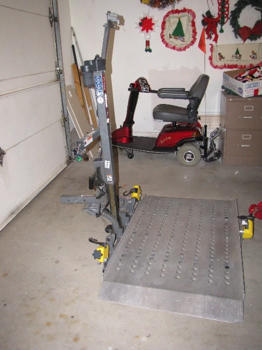 Electric chair lift that attaches to your car or truck.  Picture is taken on the side that is the ramp to drive your chair up on.