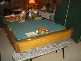 Slate top pool table.  Two Ping-Pong table tops are to the right.  Formica coffee table in foreground